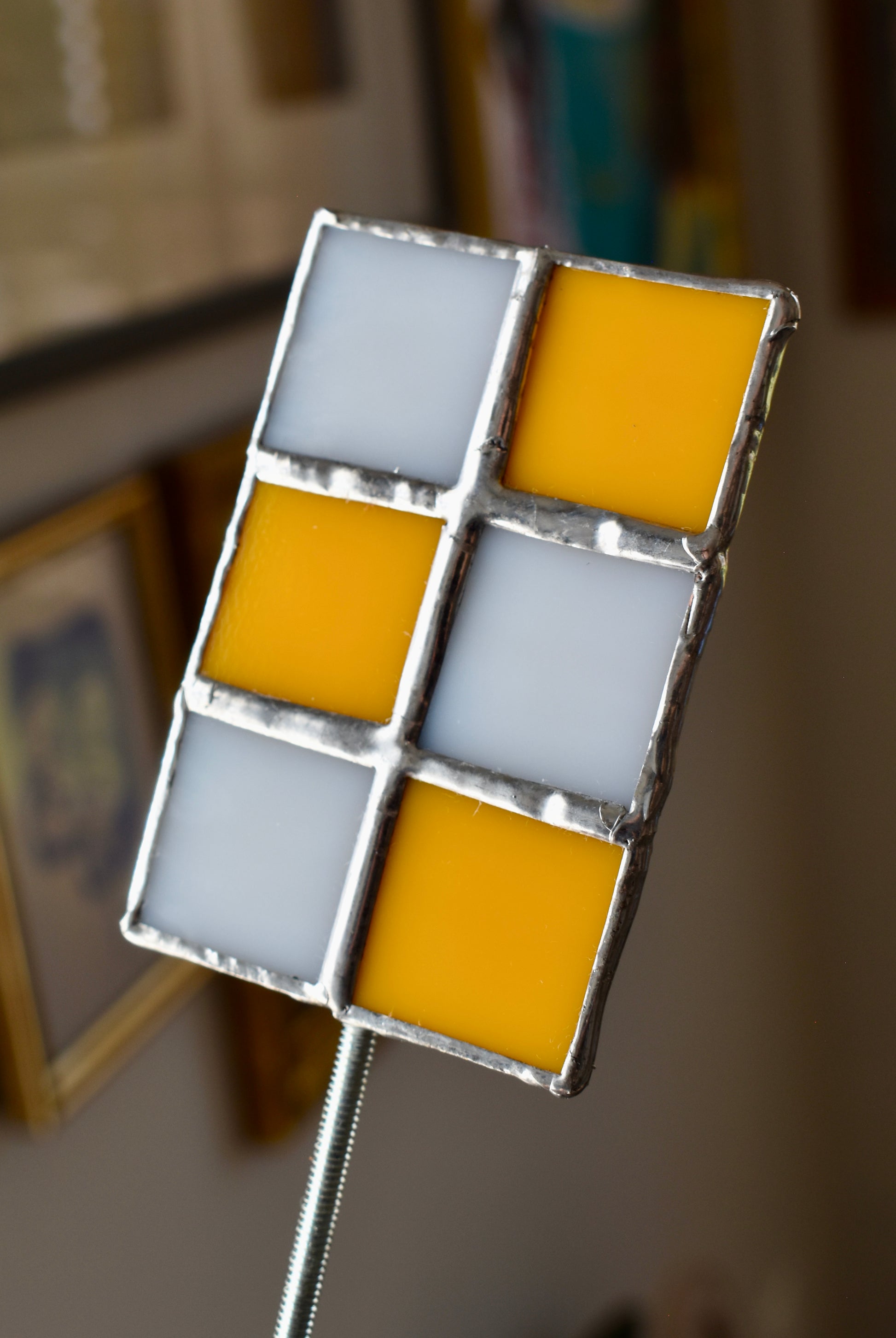 Stained glass panel with orange and white squares on a blurred background